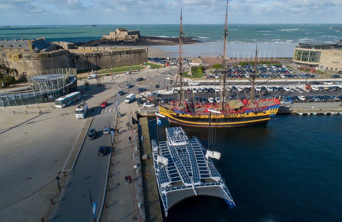 Le catamaran dans le port de Saint-Malo. En arrière plan, son vénérable ancêtre le navire "L'ETOILE DU ROY".