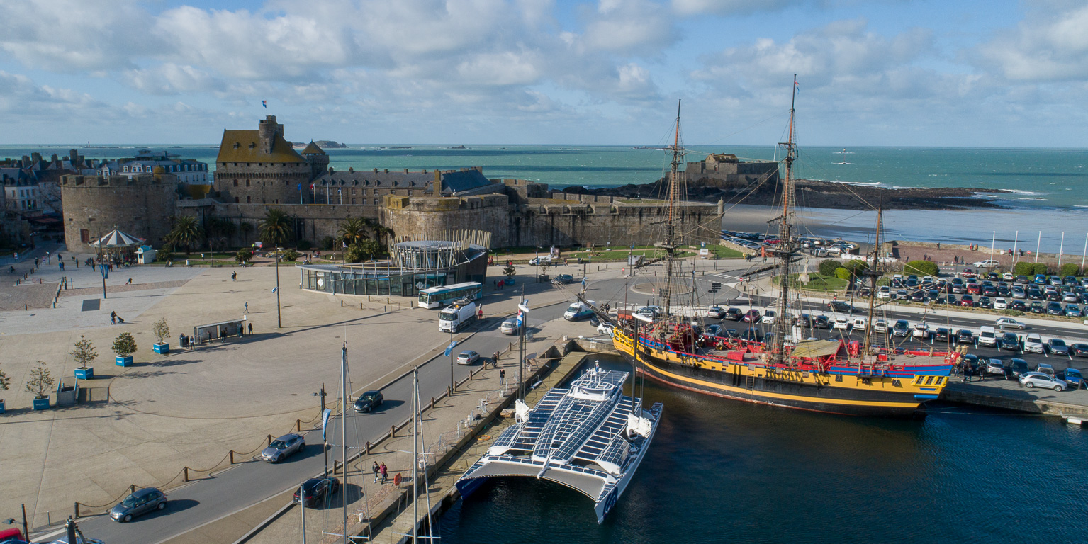 Le catamaran dans le port de Saint-Malo. En arrière plan, son vénérable ancêtre le navire "L'ETOILE DU ROY".
