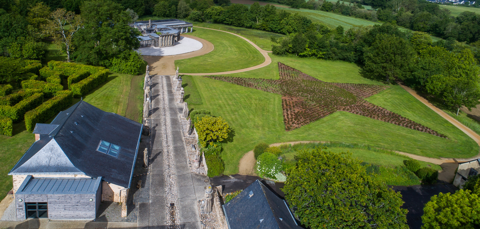 Cossé-le-Vivien. Musée Robert Tatin. L'Allée des Géants et au bout, le Jardin des Méditations.