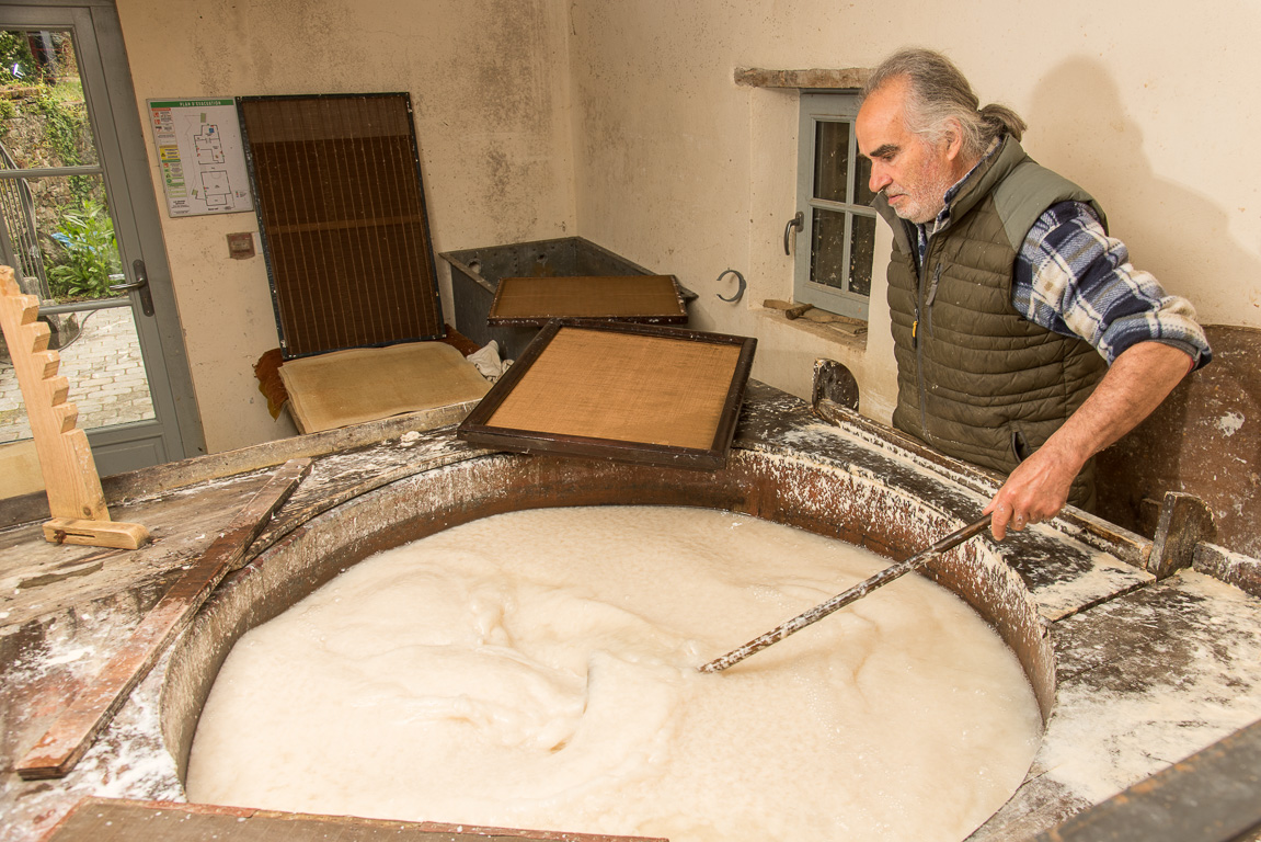 Sainte-Suzanne. Le Grand-Moulin à Papier. CUne fois que les tissus ont été broyés finement par la meule, Carlos mélange les fibres avec  l'eau.