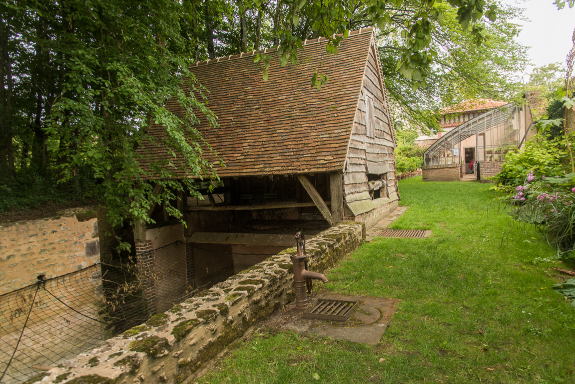 L'ancien lavoir et sa roue permettant de monter ou descendre le plancher de lavage. Le long bassin était utilisé comme vivier par les moines.