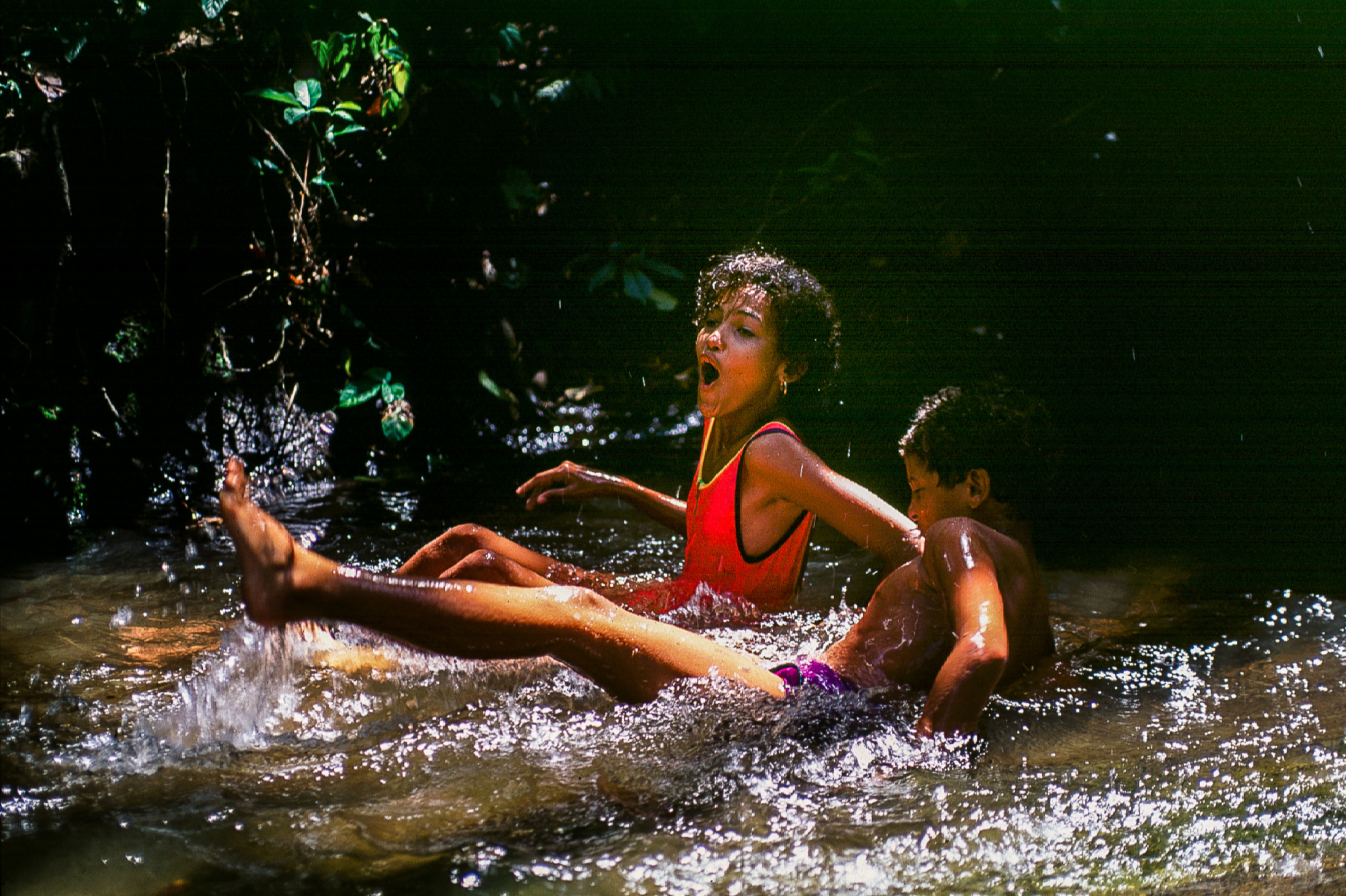 Enfants se baignant dans une cascade.