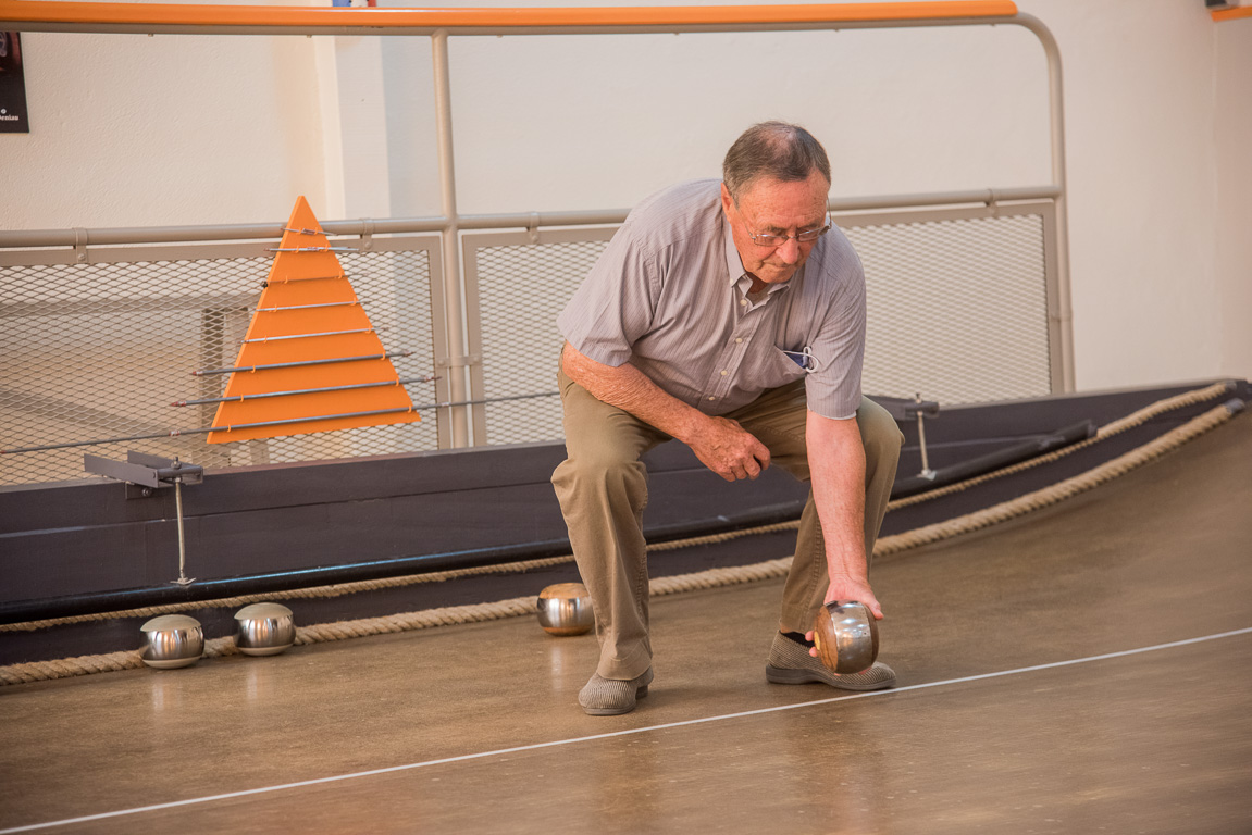 Bouchemaine, la Pointe. La Bonne Alliance association du jeu de la Boule de Fort. Le "rouleur" se baisse au maximum pour ne pas laisser tomber sa boule et l'envoie lentement, en l'accompagnant.