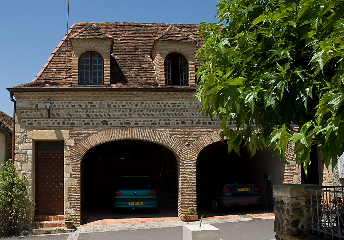 Morlanne. Toits béarnais et façade en briques colorées.