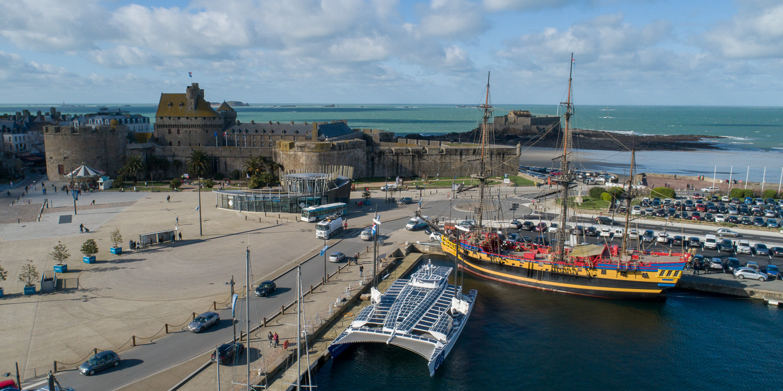 Le catamaran Energy Observer dans le port de Saint-Malo. En arrière plan, son vénérable ancêtre le navire "L'ETOILE DU ROY".
