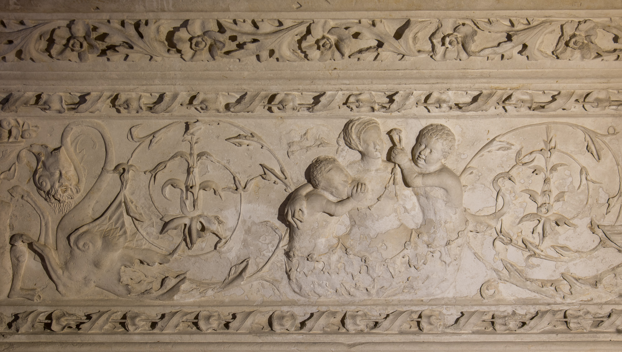 Partie d'une frise sculptée de deux hybrides et d'une figure de la Charité, décorant la galerie Nord-Est de la cour d'honneur.