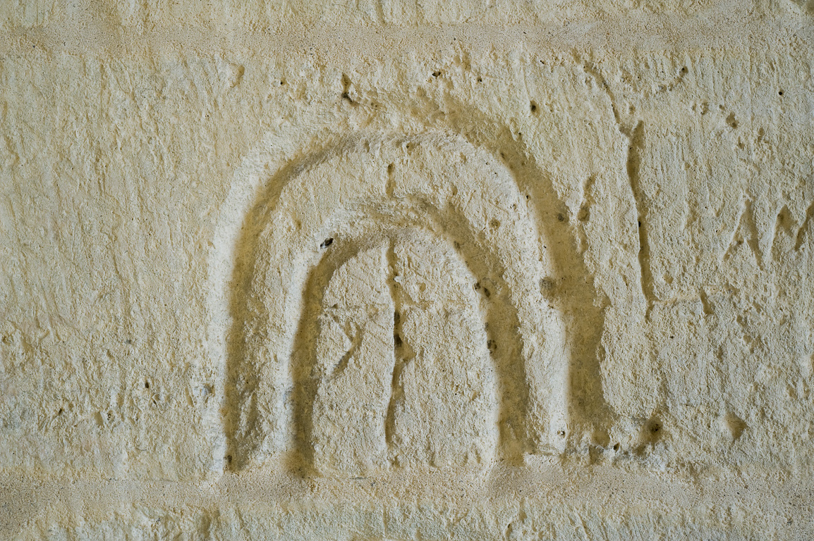 17800 Pons. Hôpital des pélerins. Le passage vouté est recouvert de graffitis exécutés par des pélerins. Ils représentent  des fers à cheval des croix d'enfeu.