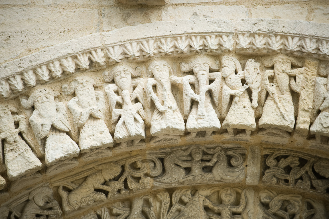 17800 Avy. Eglise romane Notre-Dame. La façade avec son portail orné de sculptures en voussure, représentant les vieillards de l'Apocalypse. Un musicien joue de l'oie".