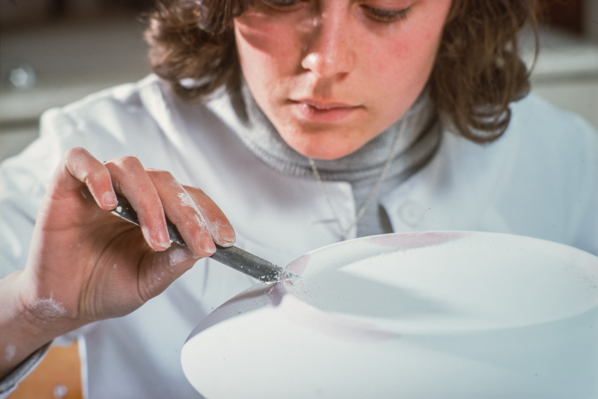 Tournassage d'une assiette à l'aide d'un trusquin sur la porcelaine sèche et non cuite.