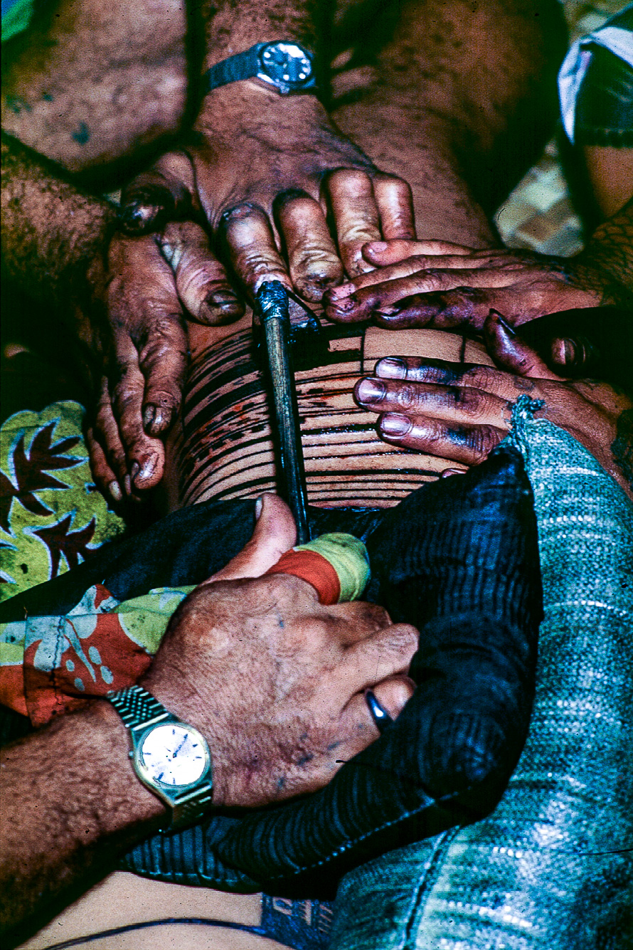 L'instrument utilisé est un peigne d'acier aux dents pointues. L'officiant trempe son outil dans l'encre et vient ensuite piquer la peau.